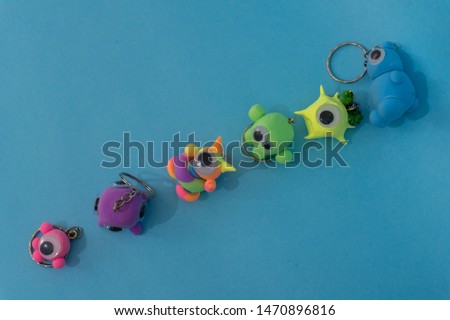a group of diferent handmade clay monsters in a minimal blue background
