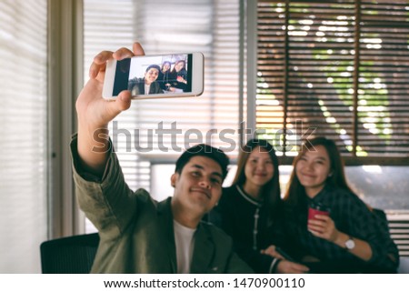 Group of businesspeople using mobile phone to take a selfie together