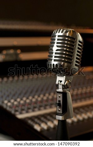 A high quality classic microphone in a recording studio environment.