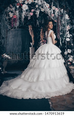 Bride in the park is a beautiful long wedding dress. Luxurious woman in a wedding dress in Paris on the Elysian fields. Happy bride