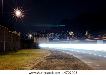 Highway traffic at night, long exposure, light streaks.