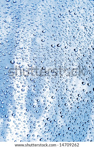Beautiful abstraction with water drops over blue glass background(shallow dof)