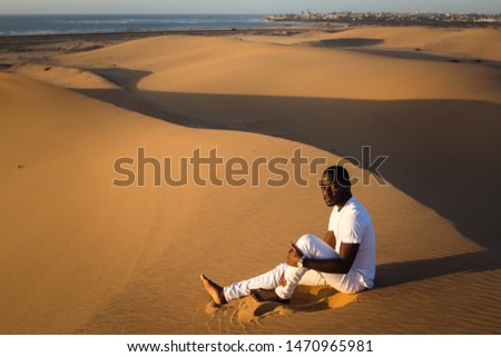Black man sitting in the desert