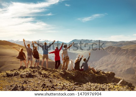Big group of happy friends or tourists are having fun in mountains