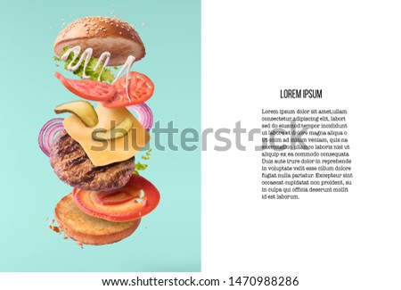 Delicious burger with flying ingredients isolated on turquoise background. Food levitation concept. High resolution image