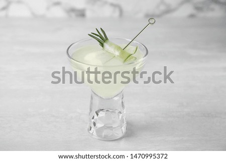 Glass of tasty cucumber martini on grey table