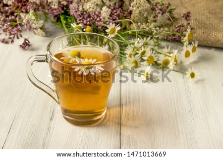 Chamomile tea, health-enhancing drink in a glass mug.