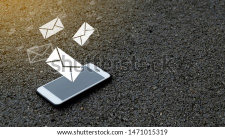 Mobile phones, smartphones with media icons and text symbols email on the paved road.