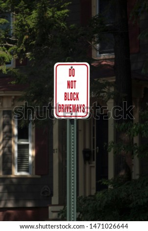 Do not Block Driveways road sign made in white and red letters attached to a pole