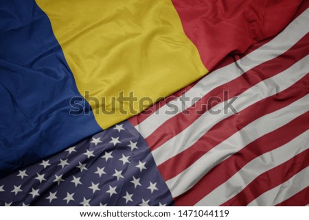 waving colorful flag of united states of america and national flag of romania.