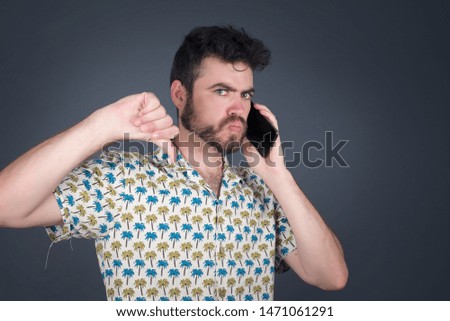 Young caucasian blue eyed man with bad news on his cell phone disapproving . Negative answer