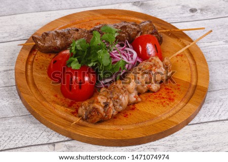 Chicken and beef skewers served gtillrf tomato and parsley