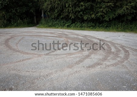 Tyre tracks left on a gravel parking lot