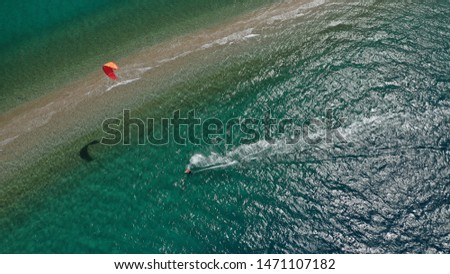 Aerial drone photo of kite surfers practising in beautiful and safe from waves sand bar separating turquoise sea in Greek Aegean island