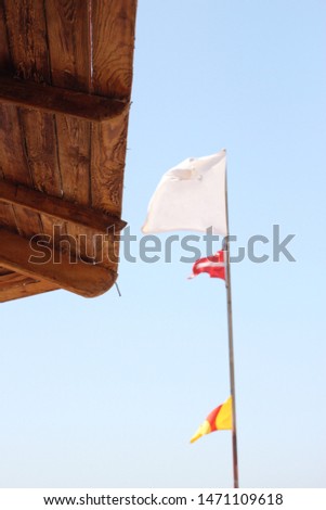 White flag and part of the tent on the beach