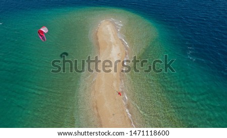 Aerial drone photo of kite surfers practising in tropical exotic bay with beautiful sand bar separating sea in two turquoise and sapphire parts
