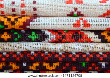 Stack of traditional Ukrainian folk art knitted embroidery patterns on textile fabric