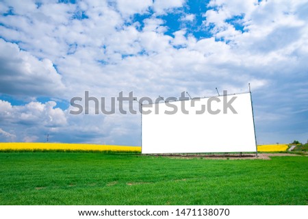 Blank white banner/billboard on the meadow near the road