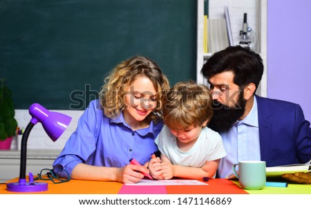 School. School boy in first grade. Happy family schooling math together. Cute pupil and his father and mother making homework. Little boy and his parents. Back to school. Home schooling. September 1.