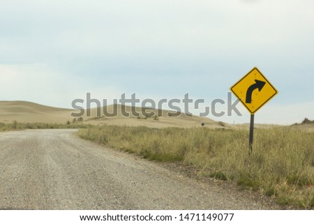 Road sign in a desert, with cloudy sky background