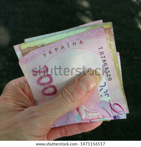 Macro photo of Ukrainian hryvnia in hand. Texture background Ukrainian bills money hryvnia in hand. Image of money 100 and 200  UAH hryvnia bill in hand
