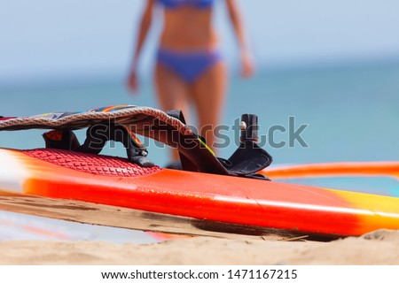 surf gear detail with blurred female and sea in the background