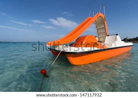 orange pedalo with water slide Royalty-Free Stock Photo #147117932