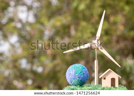 Renewable energy power future alternative, green clean electric energy for save earth concept. Home, wind turbine,globe on grass shows use of green energy for alternative of nature environmental.