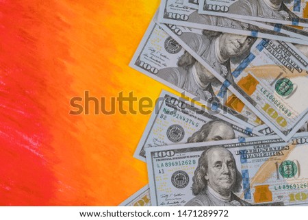 100 dollars banknotes bills on hot orange background. Money, business concept.
