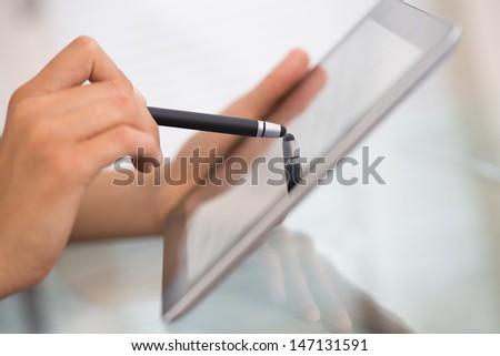 Close-up of woman working with stylus on digital tablet pc