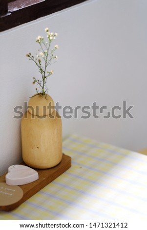 Closeup image of a small  vase and books on table in minimal cafe - Image