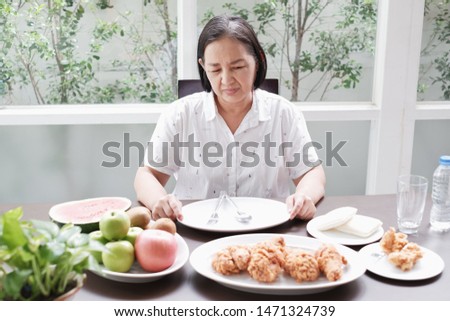 Asian Senior woman bored with food because indigestion Royalty-Free Stock Photo #1471324739