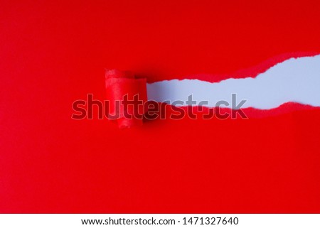 Torn red colored paper on white background with hole in the sheet of paper. Background concept with copy space.