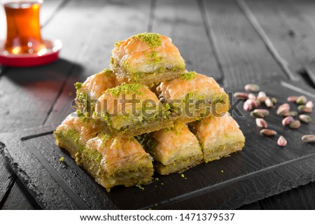Turkish ramadan dessert Baklava with pistachio and black arabian tea. Royalty-Free Stock Photo #1471379537