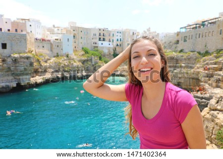 Summer holidays in Apulia. Portrait of beautiful girl with Polignano a mare landscape, Apulia, Italy.