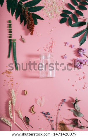 Creative flat lay top view of empty bottle mock up on pastel millennial pink paper background copy space. Minimal writing concept template for text lettering blogging.