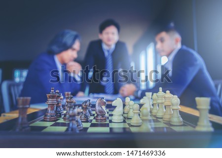 Chess on board with businessman in suit as background. Business planning strategies concept.
