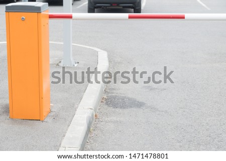 Automatic barrier in the parking lot. Summer, cloudy day.
