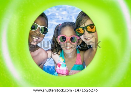 kids smiling and happy in the pool on a sunny summer day