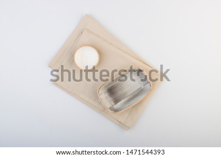 Gray rectangular plate with small bowl on cream colored napkin top view 