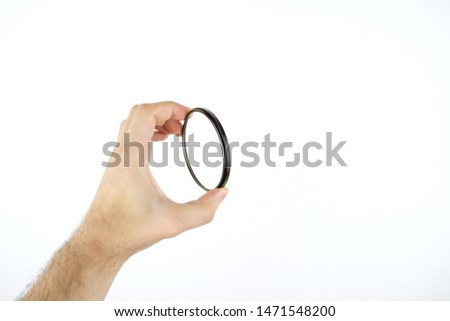 protective glass for the camera on a white background in a man’s hand