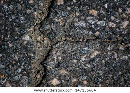A detailed close up macro photograph of cracked asphalt.  A great texture image for a background or overlay.