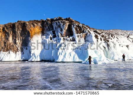 Beautiful landscape with white ice cliffs of Olkhon Island on the frozen Lake Baikal. Tourists travel and photograph unusual winter views of the Small Sea Strait