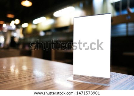 Mock up Menu frame standing on wood table in Bar restaurant cafe. space for text.