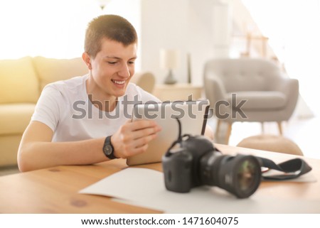 Teenage photographer with tablet computer at home