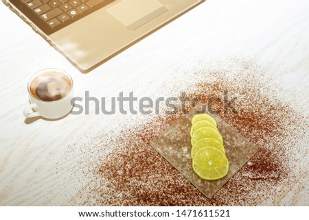 Fruits on glass saucer. Vitamins. Lemon slices. Lime, citrus. Cup of coffee. Computer.