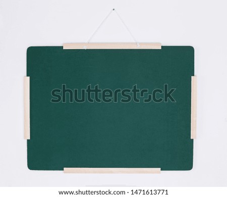 Green chalkboard hanging on white wall