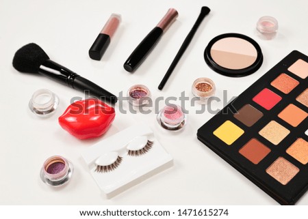 Professional makeup products with cosmetic beauty products, eye shadows, pigments, lipsticks, brushes and tools. Space for text or design.
