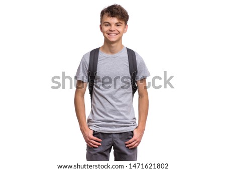 Student teen boy with backpack looking at camera. Portrait of cute smiling schoolboy with hands in pockets, isolated on white background. Happy child Back to school.