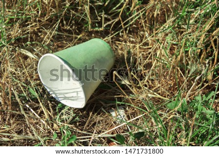 Disposable dishes are thrown out among the green grass. nature pollution concept